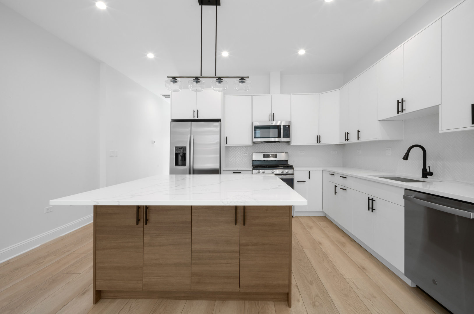 70 East Pershing Road, Unit 4W Chicago, IL 60653 - Photo 2 of 9 a kitchen with kitchen island white cabinets and stainless steel appliances