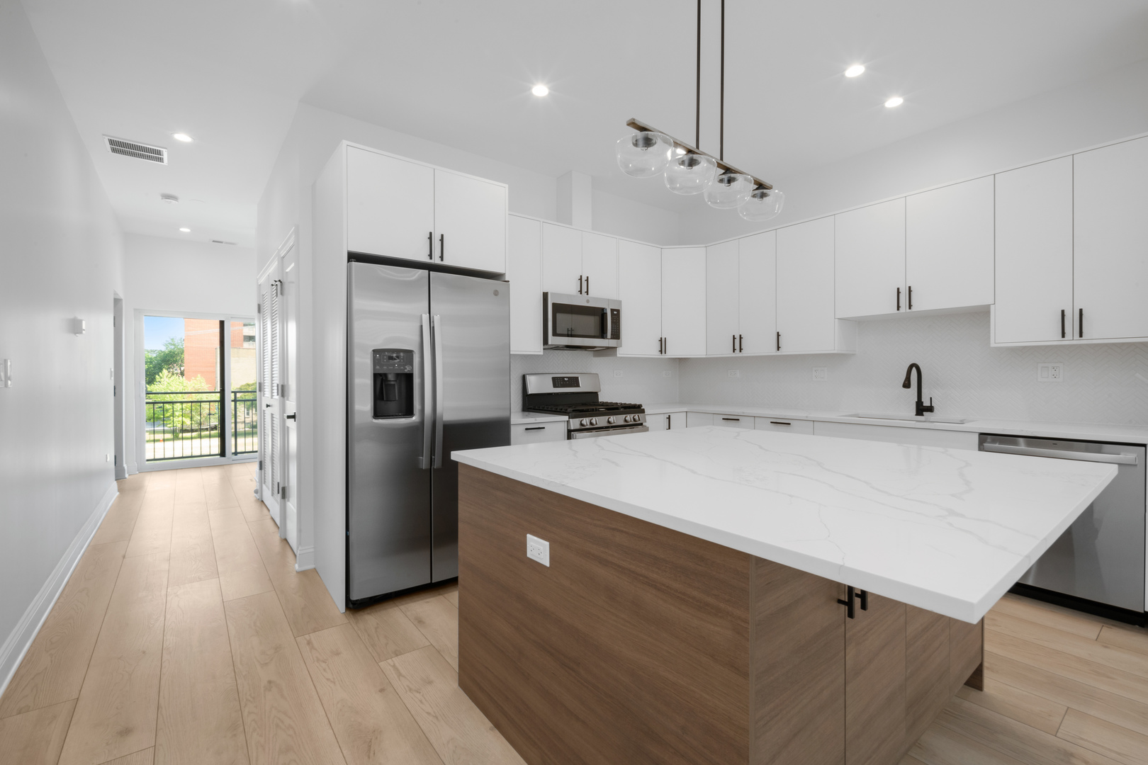 70 East Pershing Road, Unit 4W Chicago, IL 60653 - Photo 3 of 9 a kitchen with kitchen island a sink stainless steel appliances and cabinets