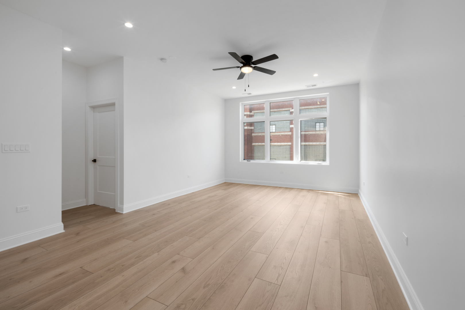 70 East Pershing Road, Unit 4W Chicago, IL 60653 - Photo 5 of 9 a view of an empty room with wooden floor and a window