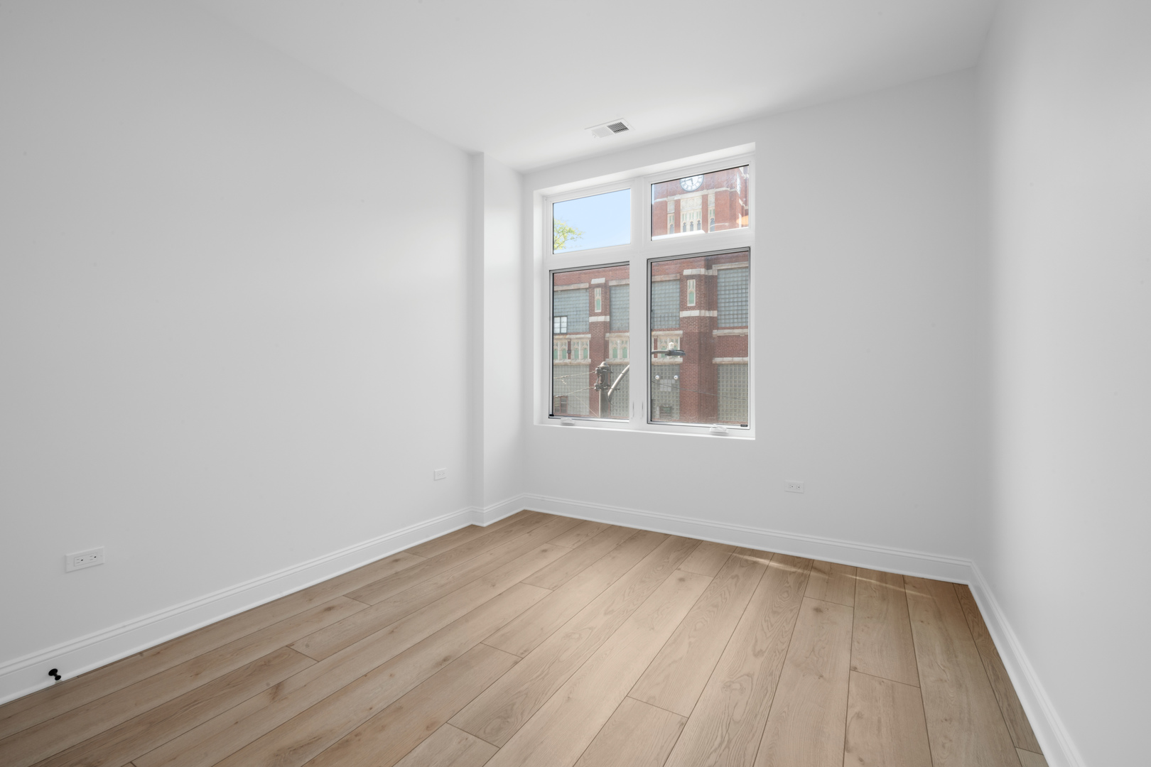 70 East Pershing Road, Unit 4W Chicago, IL 60653 - Photo 7 of 9 an empty room with wooden floor and windows