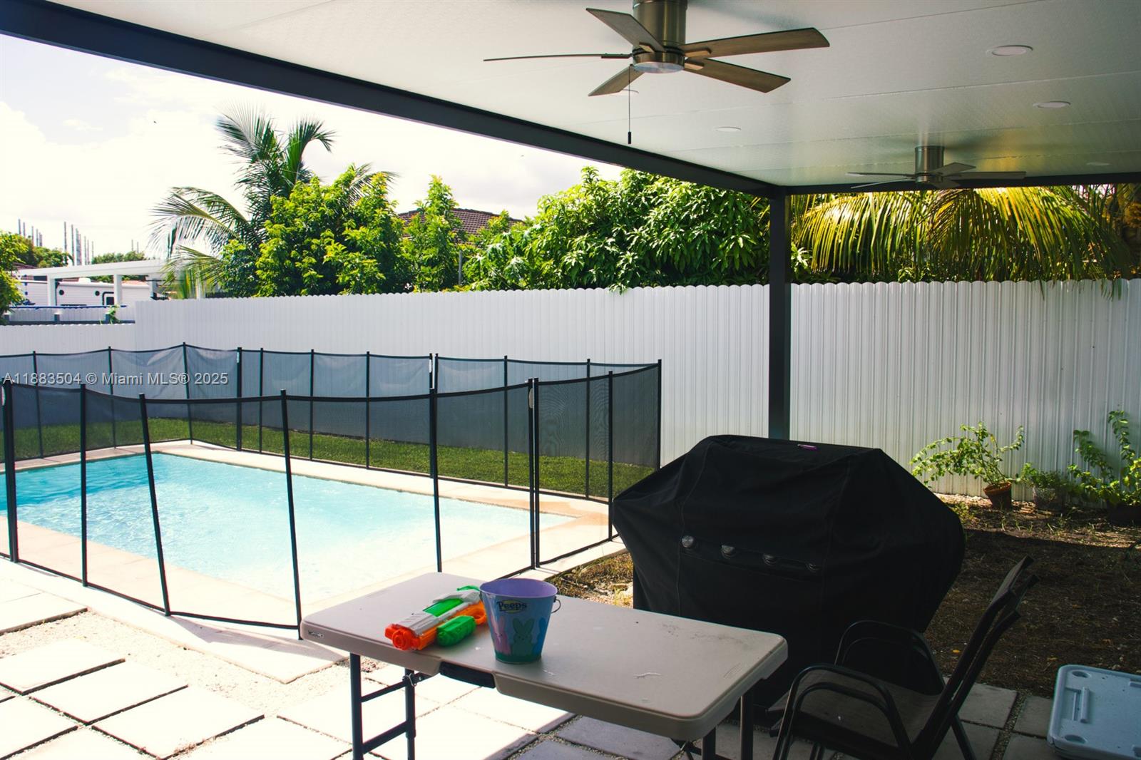 25760 Southwest 127th Court Homestead, FL 33032 - Photo 16 of 25 a living room with a floor to ceiling window and a glass table