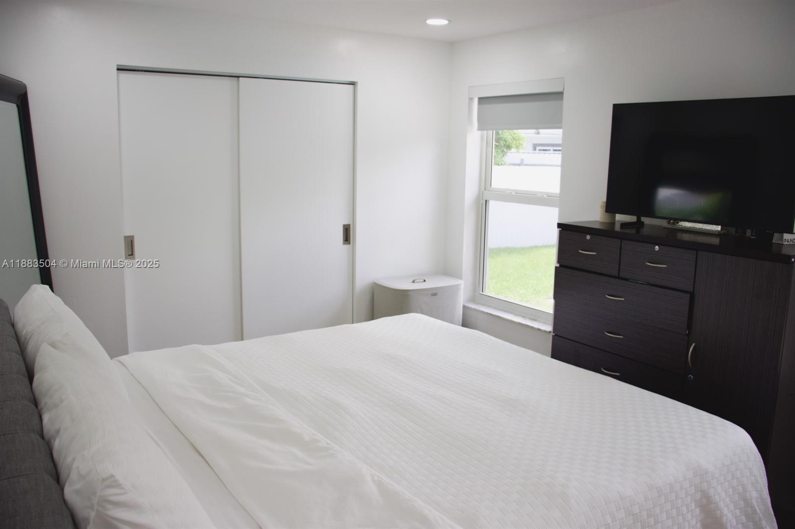 25760 Southwest 127th Court Homestead, FL 33032 - Photo 21 of 25 a bedroom with a bed and a flat tv screen on dresser