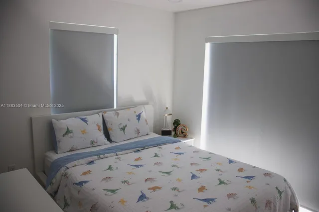 a large bed sitting in a bedroom next to a window