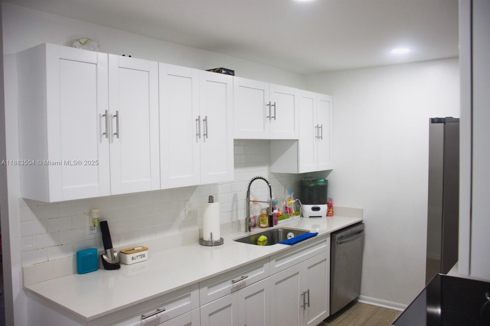 25760 Southwest 127th Court Homestead, FL 33032 - Photo 9 of 25 a kitchen with stainless steel appliances granite countertop a sink a refrigerator and a white cabinets