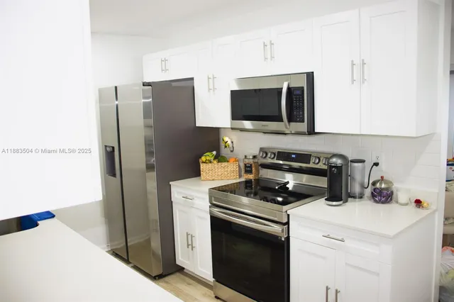 a kitchen with stainless steel appliances a refrigerator stove and microwave