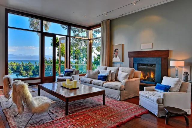 a living room with furniture fireplace and a large window