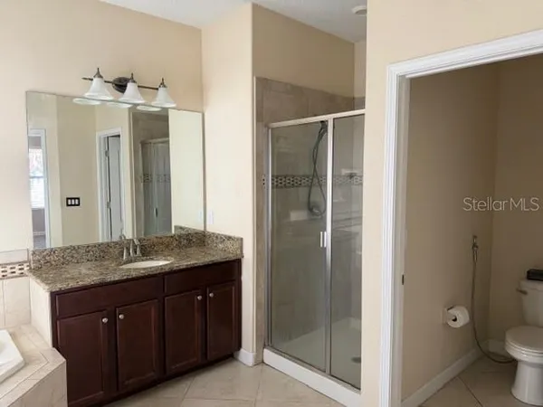 a spacious bathroom with a granite countertop sink mirror and toilet