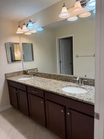 a bathroom with a granite countertop sink and a mirror