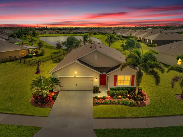 a view of a swimming pool with a table & chairs in a garden
