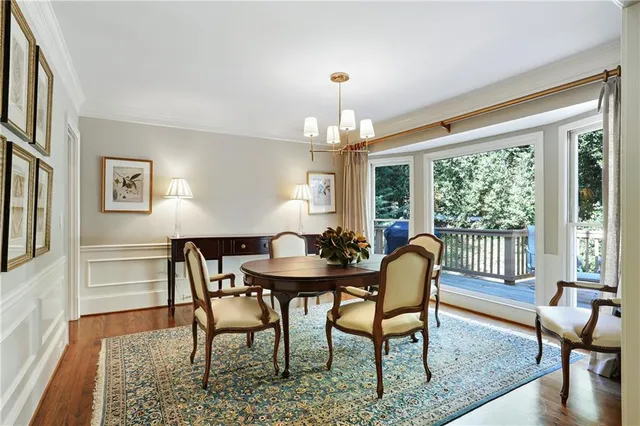 a dining room with furniture a chandelier and wooden floor