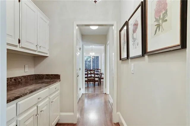 a kitchen with granite countertop white cabinets and wooden floor