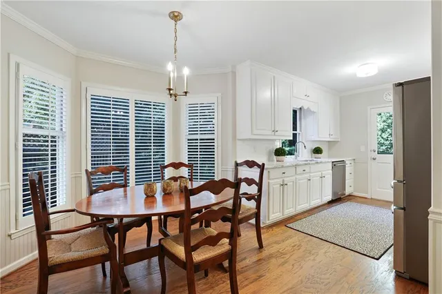 a open dining room with stainless steel appliances kitchen island granite countertop a table chairs and a refrigerator