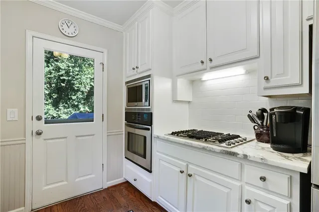 a kitchen with granite countertop white cabinets and white appliances