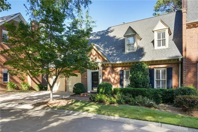 a front view of a house with a yard and potted plants