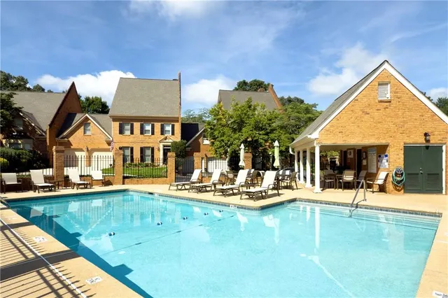 a view of a house with swimming pool and sitting area