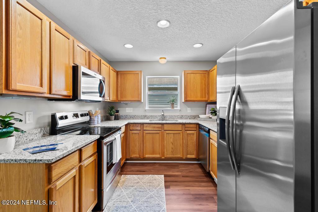96014 Morton Lane Yulee, FL 32097 - Photo 17 of 45 a kitchen with stainless steel appliances granite countertop a sink stove refrigerator and cabinets