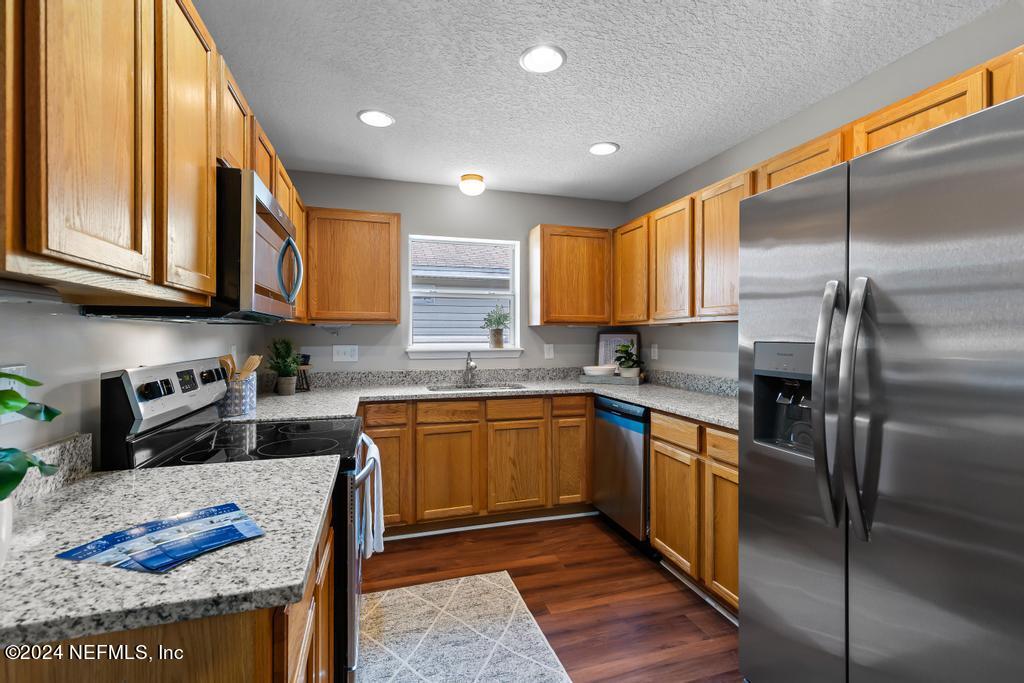 96014 Morton Lane Yulee, FL 32097 - Photo 18 of 45 a kitchen with stainless steel appliances granite countertop a sink a stove and a refrigerator