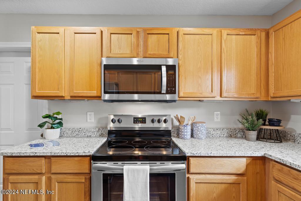 96014 Morton Lane Yulee, FL 32097 - Photo 20 of 45 a kitchen with stainless steel appliances granite countertop white cabinets sink and a granite counter top
