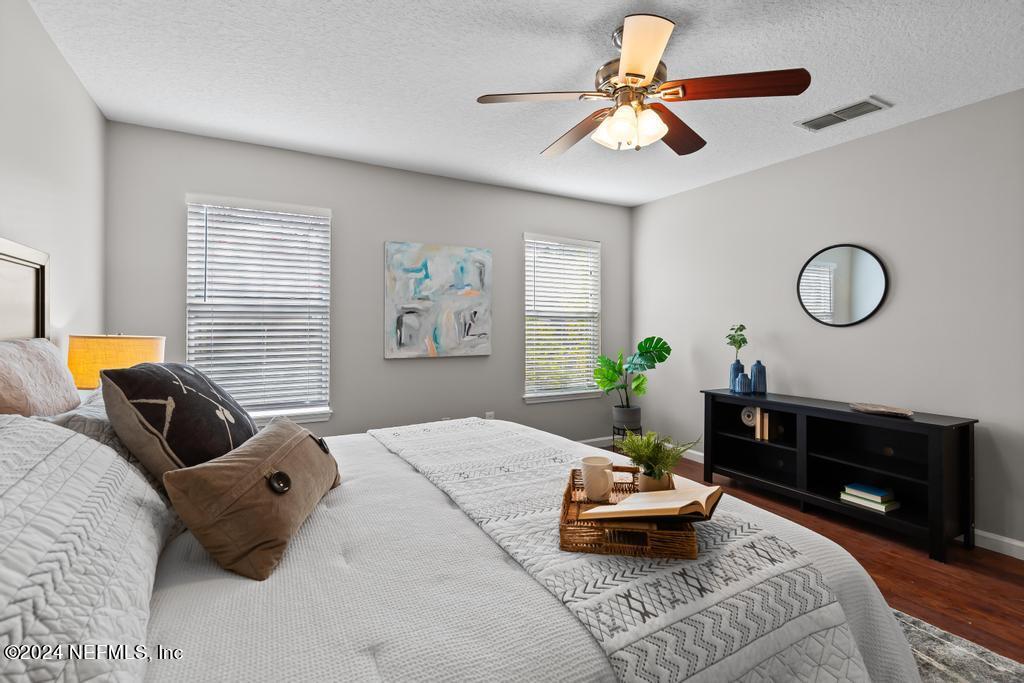 96014 Morton Lane Yulee, FL 32097 - Photo 25 of 45 a bedroom with a bed a chandelier and a window