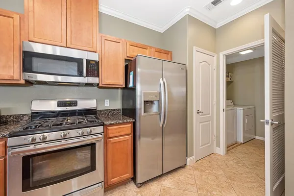 a kitchen with stainless steel appliances granite countertop a stove a microwave and a refrigerator