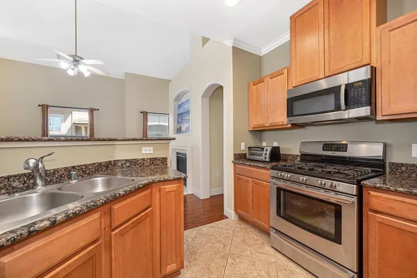 a kitchen with stainless steel appliances granite countertop a stove microwave and sink