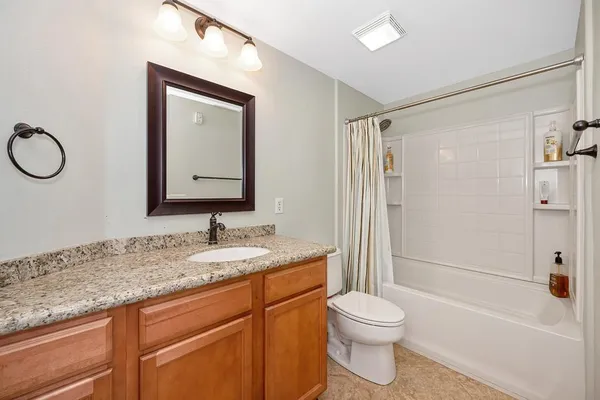 a bathroom with a granite countertop sink toilet and shower