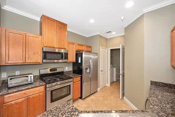 a kitchen with stainless steel appliances granite countertop a refrigerator stove and sink