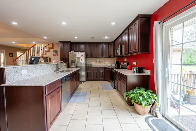 a kitchen with stainless steel appliances granite countertop a sink counter space cabinets and a large window