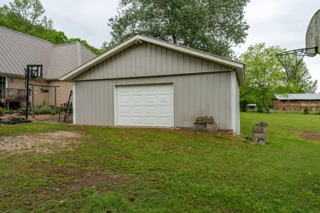 a small white house with a yard and garage