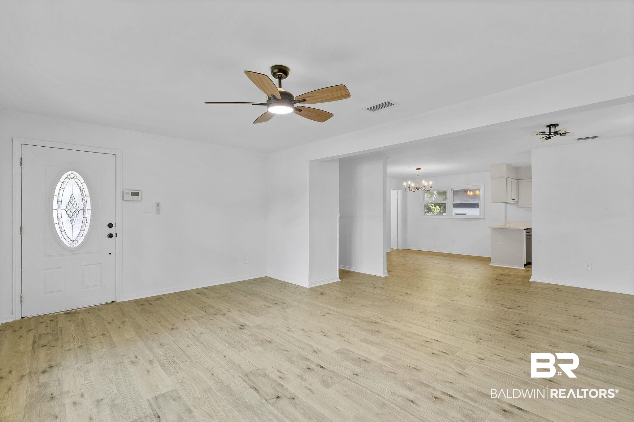 203 Anderson Road Saraland, AL 36571 - Photo 6 of 48 Foyer featuring light wood-style floors, ceiling fan with notable chandelier, baseboards, and visible vents