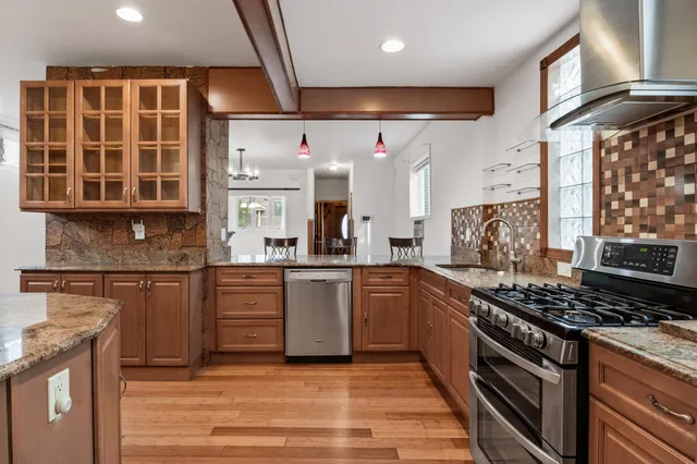 a kitchen with stainless steel appliances granite countertop a stove and a sink