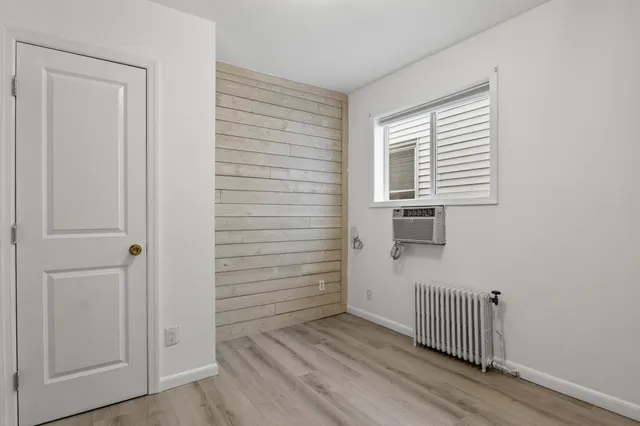 a view of a hallway with wooden floor and entryway