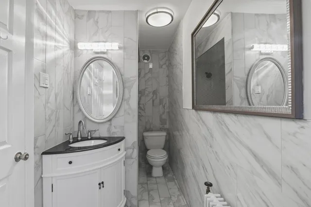 a bathroom with a toilet a sink and a mirror