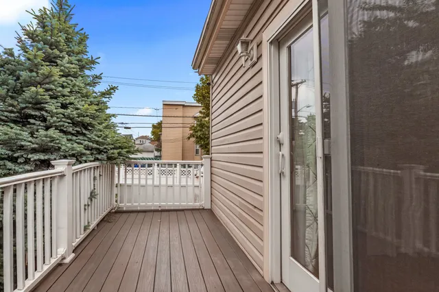 a view of a balcony with wooden floor and fence