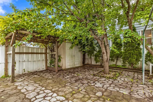 a front view of a house with a tree