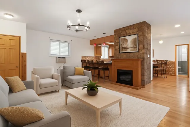 a living room with furniture a fireplace and a chandelier