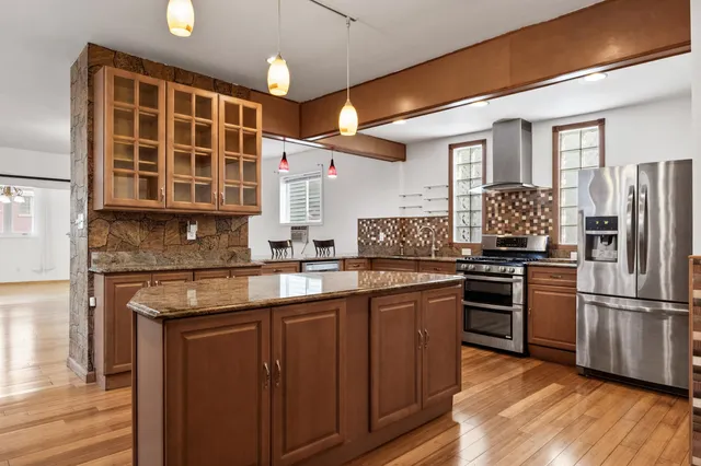 a kitchen with stainless steel appliances granite countertop a stove and a refrigerator