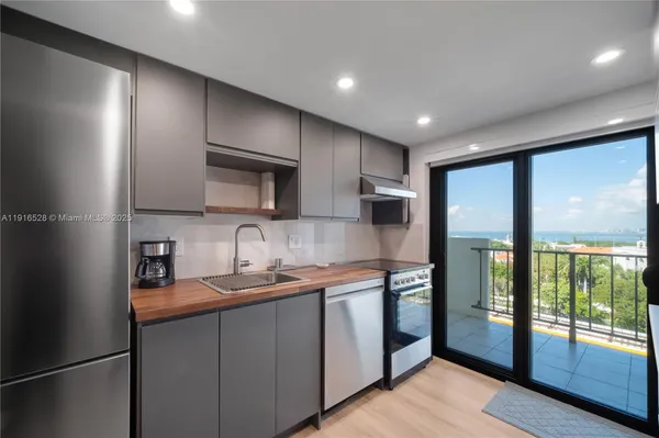 a kitchen with stainless steel appliances granite countertop a refrigerator a sink and a stove