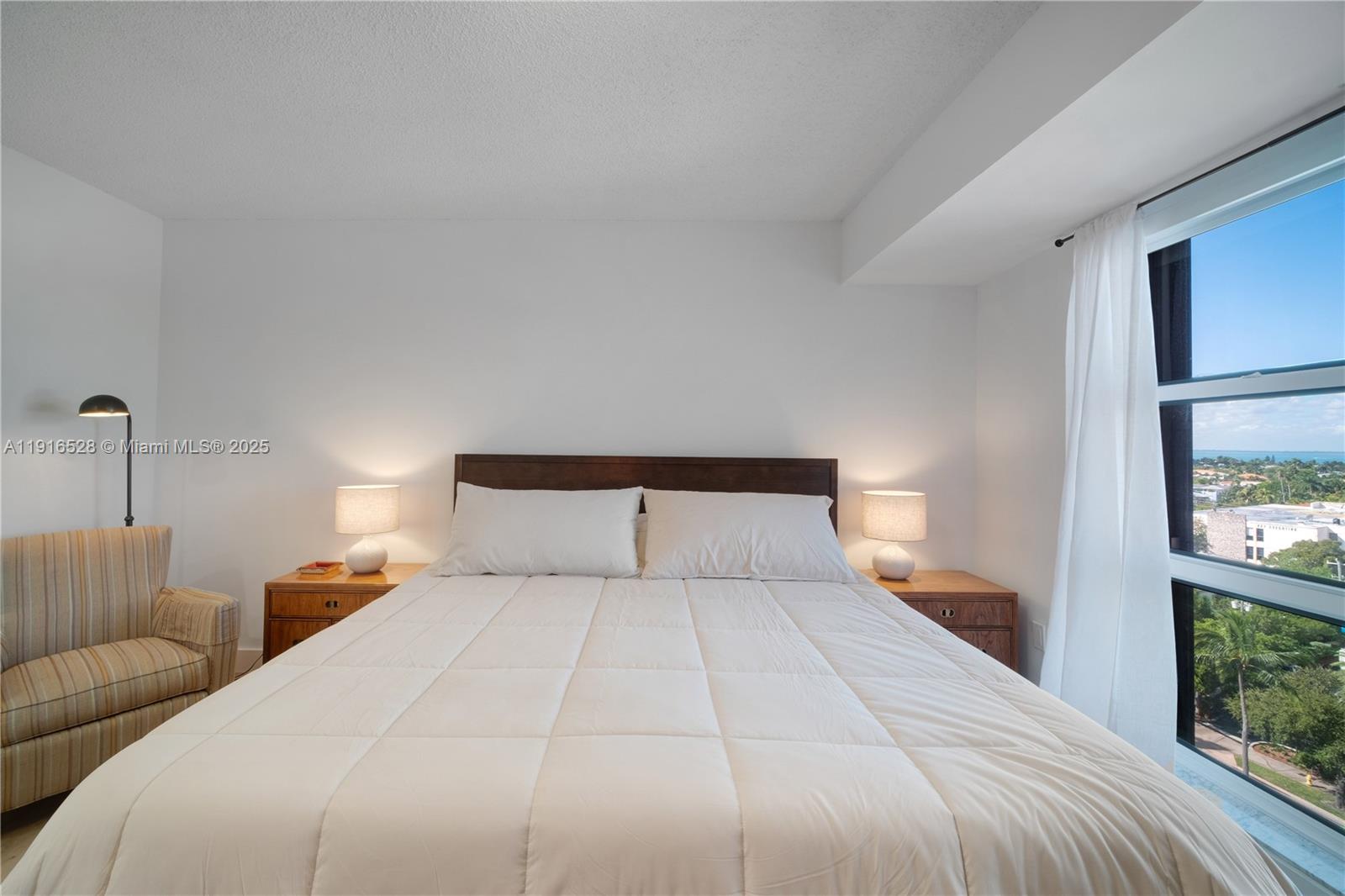 77 Crandon Boulevard, Unit 10C Key Biscayne, FL 33149 - Photo 21 of 37 a bedroom with a large bed and a night stand