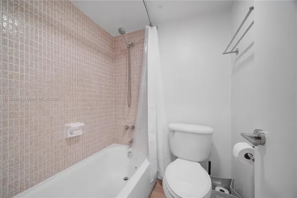 a white toilet sitting next to a bath tub