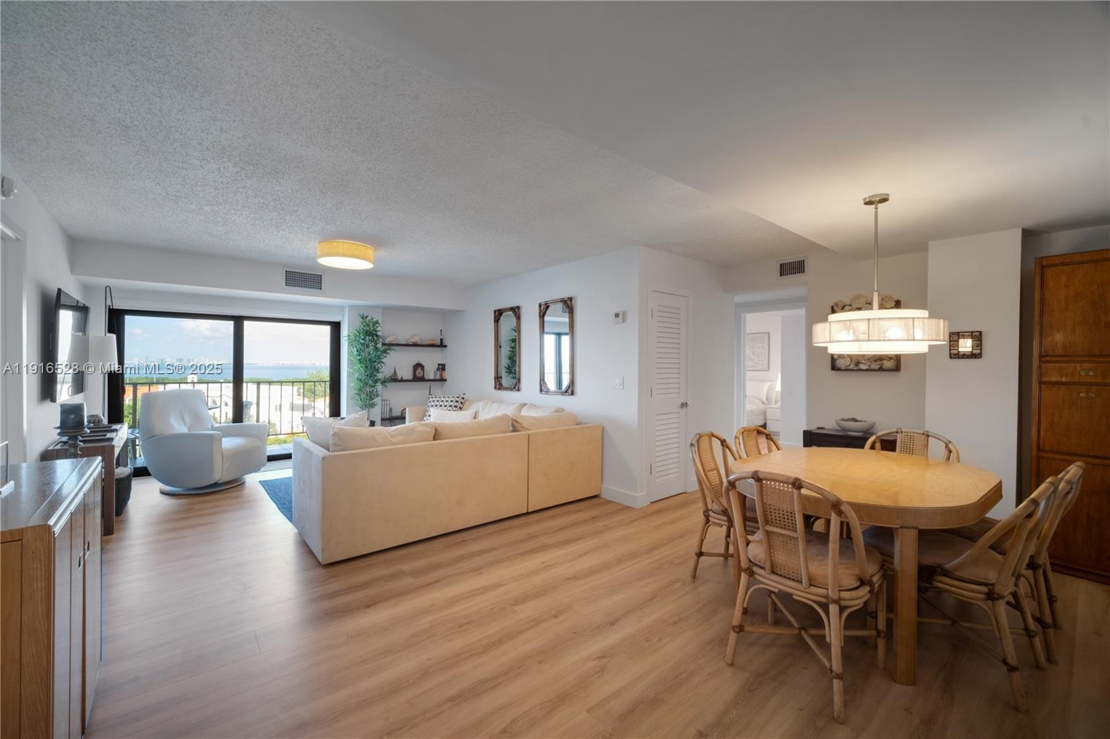 77 Crandon Boulevard, Unit 10C Key Biscayne, FL 33149 - Photo 5 of 37 a view of a dining room with furniture and wooden floor