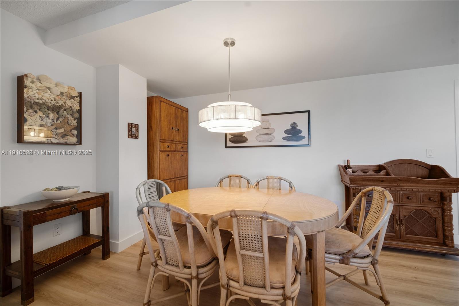 77 Crandon Boulevard, Unit 10C Key Biscayne, FL 33149 - Photo 10 of 37 a view of a dining room with furniture wooden floor and chandelier