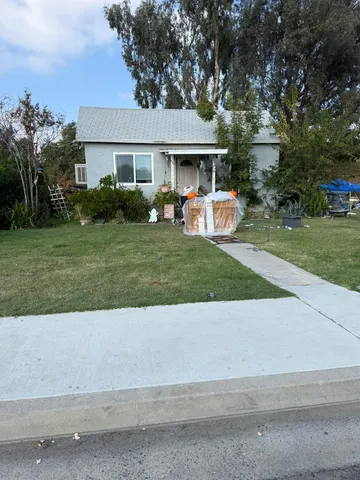 a front view of a house with a garden and trees