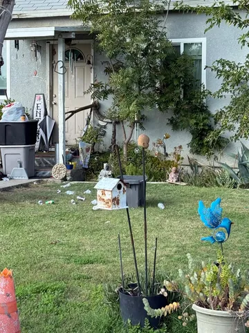 a backyard of a house with table and chairs potted plants