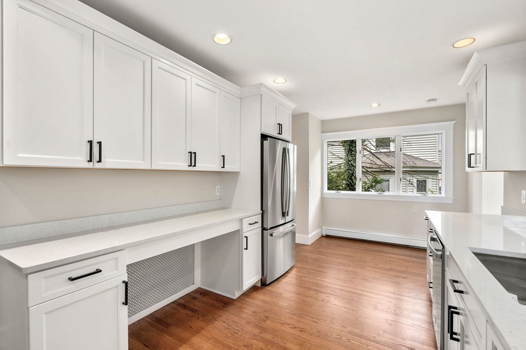 95 Russett Road Boston, MA 02132 - Photo 11 of 42 a kitchen with stainless steel appliances granite countertop a refrigerator a sink and white cabinets with wooden floor
