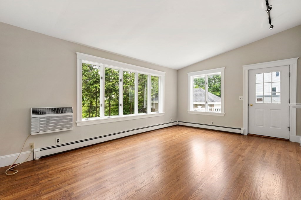 95 Russett Road Boston, MA 02132 - Photo 16 of 42 an empty room with wooden floor and windows