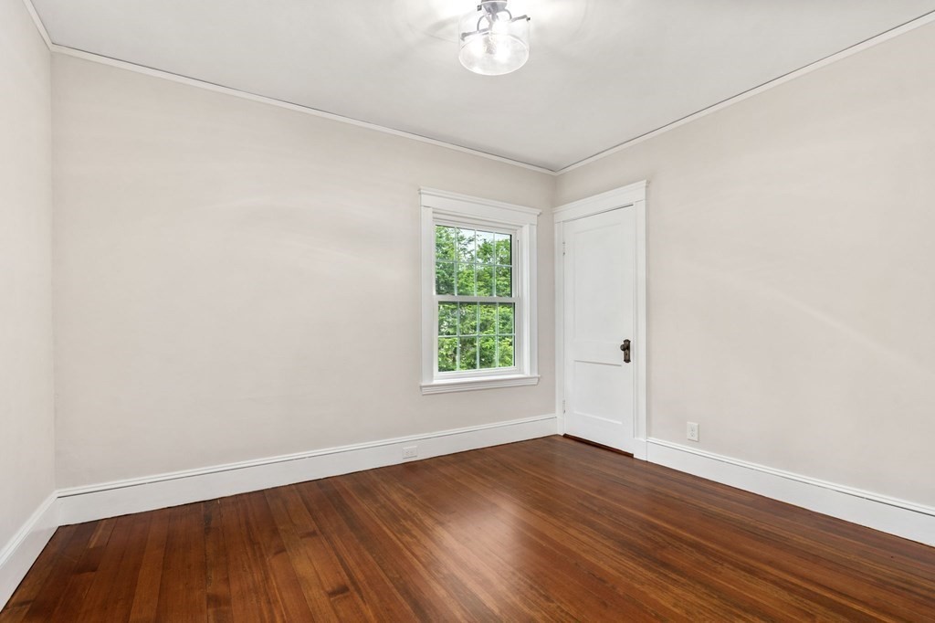 95 Russett Road Boston, MA 02132 - Photo 21 of 42 an empty room with wooden floor and windows