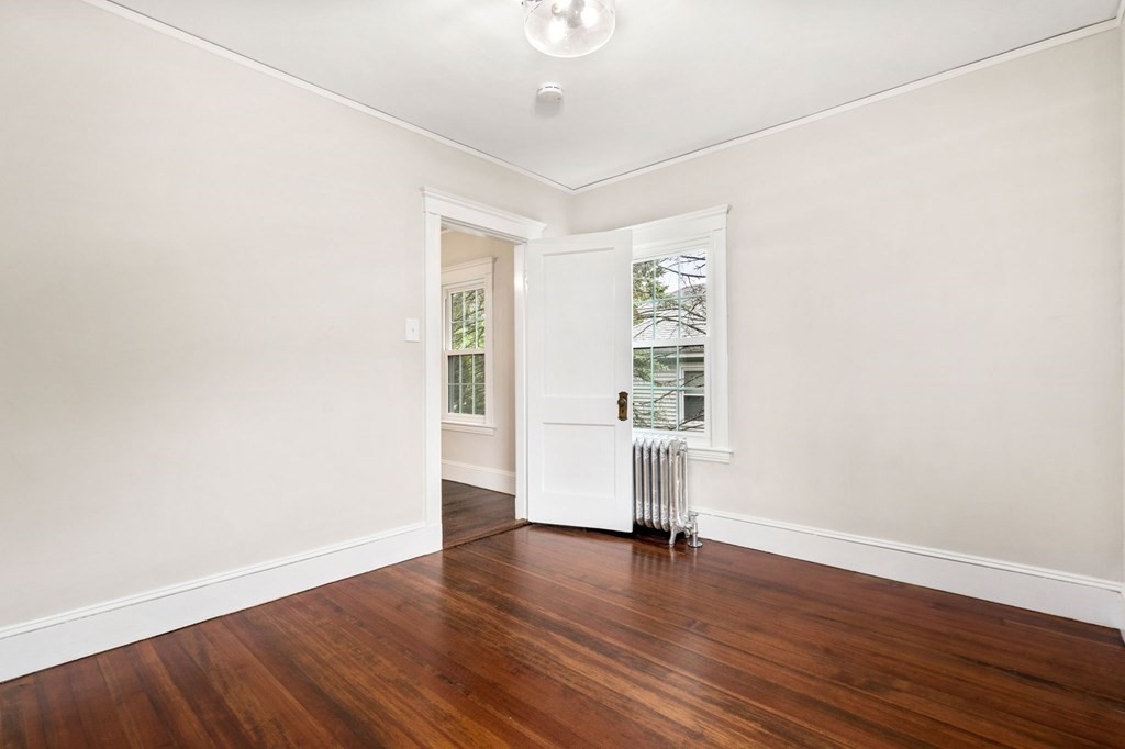 95 Russett Road Boston, MA 02132 - Photo 22 of 42 an empty room with wooden floor and windows