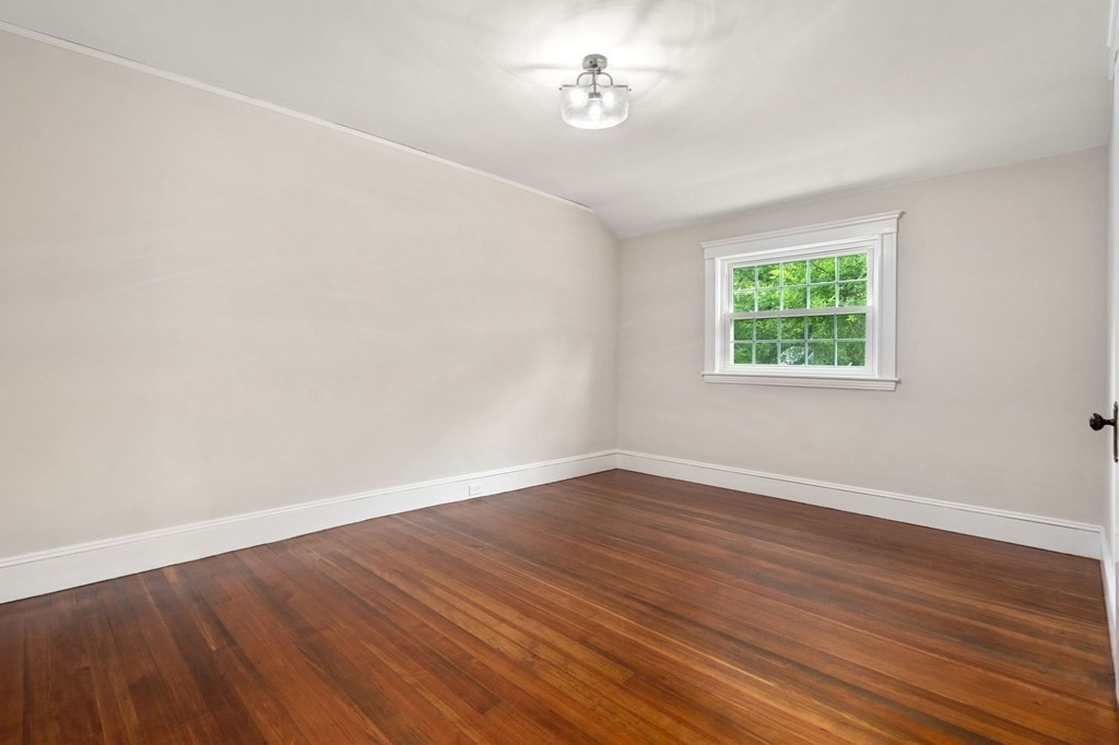 95 Russett Road Boston, MA 02132 - Photo 23 of 42 an empty room with wooden floor and windows