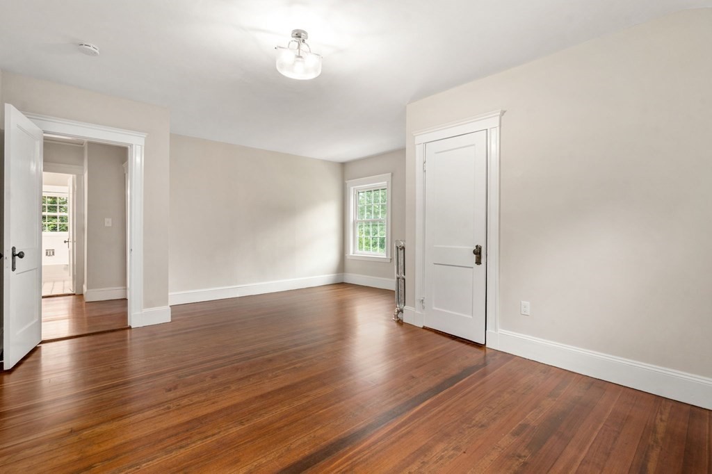 95 Russett Road Boston, MA 02132 - Photo 26 of 42 an empty room with wooden floor and windows